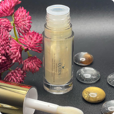 A bottle of golden liquid placed beside a blooming flower on a soft surface, creating a serene and elegant composition.