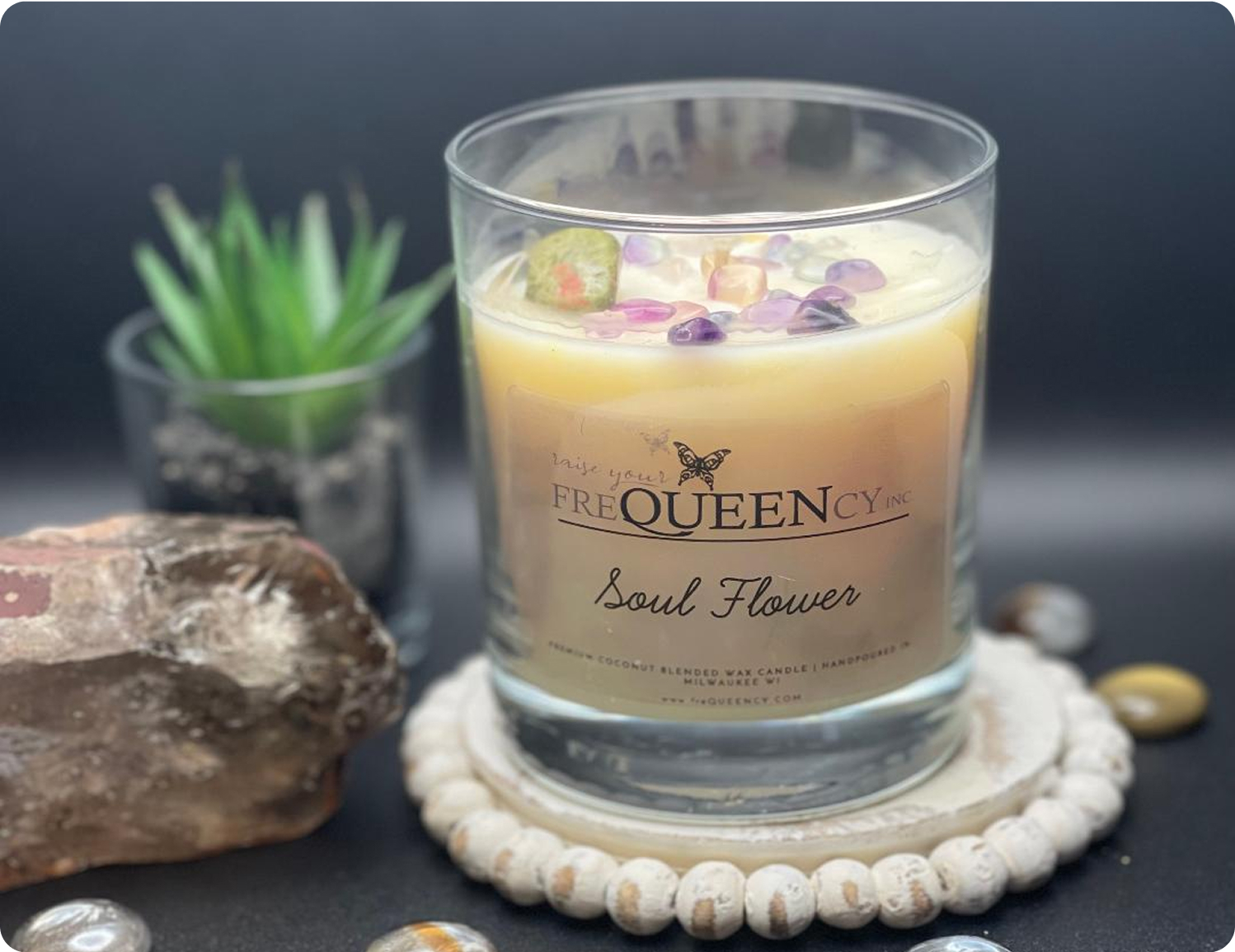 A colorful flower candle with intricate petal details, radiating light, set against a rustic wooden background.