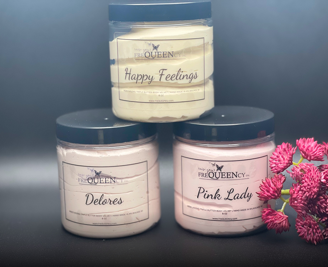Three jars of body butter arranged with pink flowers, showcasing a natural and soothing skincare aesthetic.